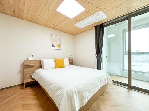a bedroom with a bed and a large window at Brown Suites Busan Station in Busan