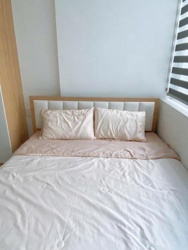 a bed with white sheets and pillows in a room at Châu Giang Homestay, Nera Garden Huế in Thôn Văn Dương
