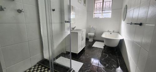 a bathroom with a shower and a sink and a toilet at Carrington Guesthouse in Kimberley