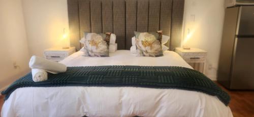 a bedroom with a large white bed with two lamps at Carrington Guesthouse in Kimberley