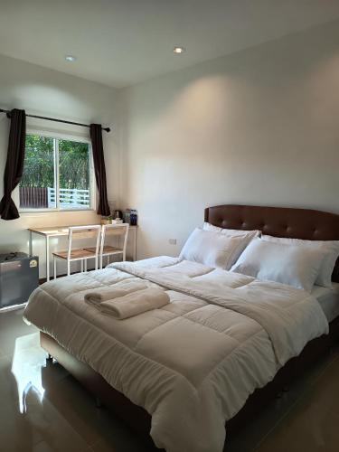 a bedroom with a large bed and a table at Good Nine Resort in Ban Lam Kaen