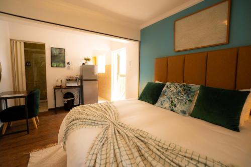 a bedroom with a large bed and a desk at Die Stalle in Klerksdorp