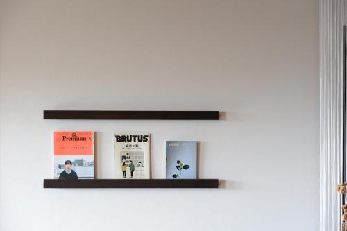 a shelf on a wall with books on it at 火口に最も近い桜島のゲストハウスikoてらす in Kagoshima