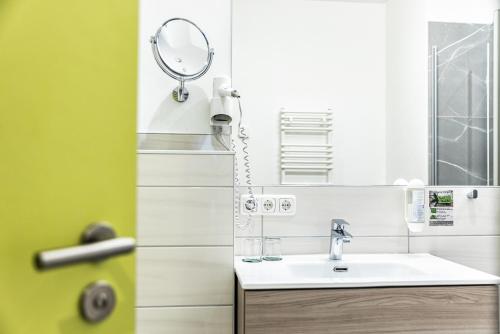 a bathroom with a sink and a mirror at Hotel Bannewitz B&B in Bannewitz