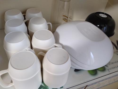 a group of white cups sitting on a counter at Hostel 鶴々 in Shingu