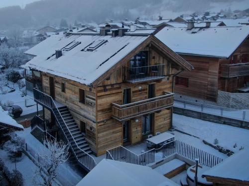 a large wooden house with snow on the roof at Chalet Alpenglück by Kaprun Rentals in Kaprun