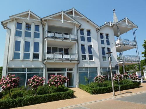 a large white building with balconies and flowers at AKZENT Waldhotel Spa Rügen in Göhren