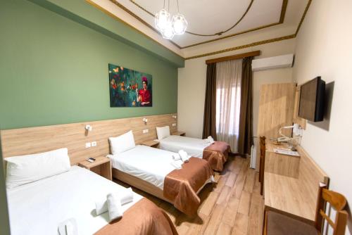 a hotel room with two beds and a flat screen tv at Nea Metropolis in Thessaloniki