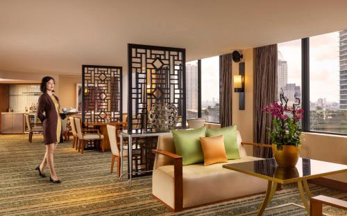 a woman standing in a room with a living room at Mandarin Oriental, Jakarta in Jakarta