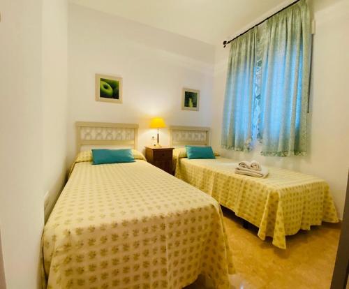 a bedroom with two beds and a window at Bajo La Higuera FAMORCAS in Almodóvar del Río