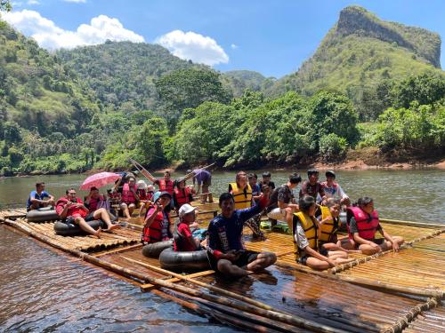 a group of people sitting on a raft on a river at Khao Phang Camping in Ban Pha Saeng Lang