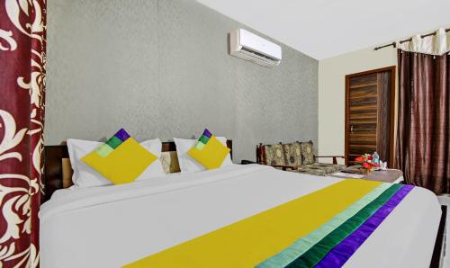 a bedroom with a large bed with colorful pillows at Hotel King Palace Near CP 67 Mall Airport Road Mohali in Sohāna