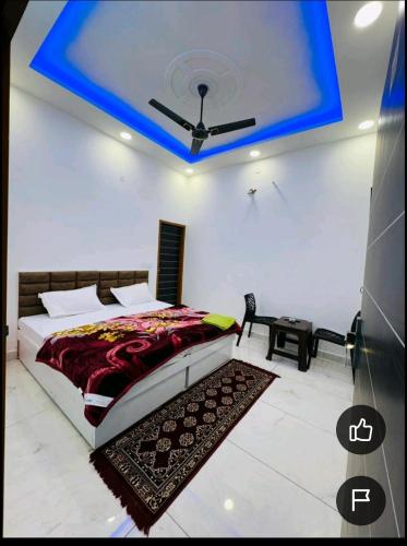 a bedroom with a bed with a blue ceiling at Mahima hotel in Samālkha