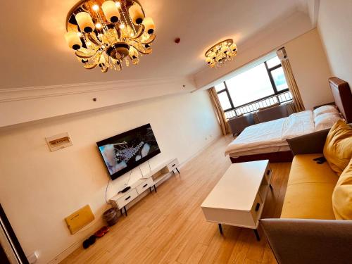 a large living room with a couch and a chandelier at JiuJiu Binhai Hotel in Huangdao