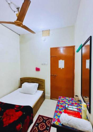 a small bedroom with a bed and a door at Hotel Padma Dhaka in Dhaka