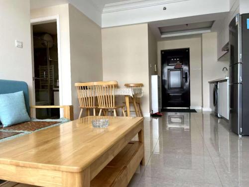 a living room with a wooden table and chairs at JiuJiu Binhai Hotel in Huangdao