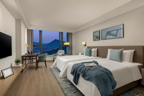 Voodi või voodid majutusasutuse Qingshan Lake Tianlan Hotel Hangzhou toas