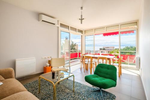 - un salon avec une table et une chaise verte dans l'établissement Appartement Les Amandiers, à Cagnes-sur-Mer