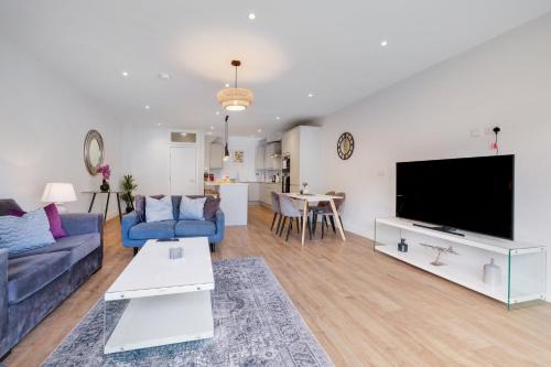 a living room with a couch and a tv at Luxury 5 Bedroom, 4 Bathroom Home in Purley in Purley