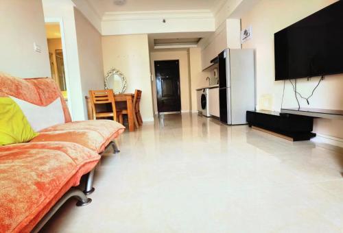 a living room with a couch and a television at JiuJiu Binhai Hotel in Huangdao