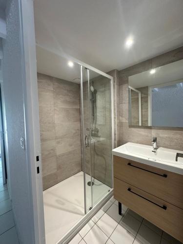 une salle de bain avec une douche en verre et un lavabo dans l'établissement Villa Patio Hossegor lake and ocean, à Hossegor