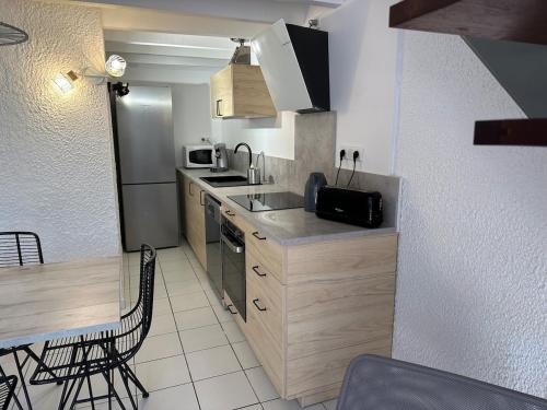 une petite cuisine avec un évier et un micro-ondes dans l'établissement Villa Patio Hossegor lake and ocean, à Hossegor