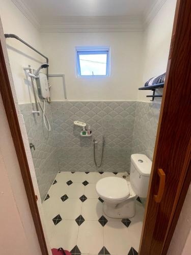 a bathroom with a white toilet and a shower at Laman tokma in Kota Bharu