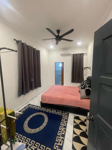 a bedroom with a bed and a ceiling fan at Laman tokma in Kota Bharu