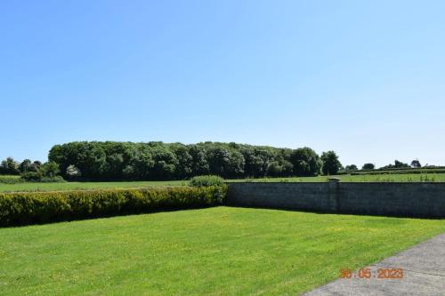 a large yard with a retaining wall and grass at Hillgrove, Borrisokane in Goatstown