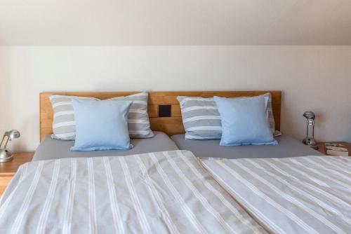 a bedroom with a bed with blue and white pillows at Ferienwohnung Roth in Überlingen