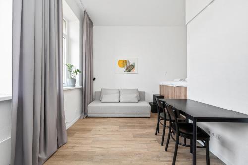 a dining room with a table and chairs and a couch at Air Apartments - Code entry only, No staff in Vilnius