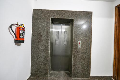 a elevator in a building with a fire extinguisher at FabHotel Luxe 8 Stayz - Phase 1 Metro, Golf Course Road & Arjun Marg in Gurgaon