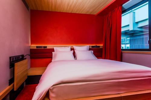 a bedroom with a large bed with a red wall at YOOMA Urban Lodge Tour Eiffel in Paris