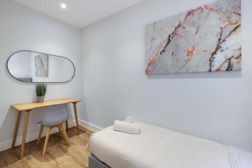 a bedroom with a bed and a desk and a mirror at Luxury 5 Bedroom, 4 Bathroom Home in Purley in Purley