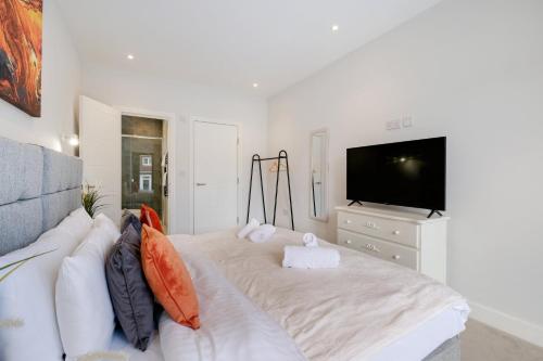 a living room with a white couch and a tv at Luxury 5 Bedroom, 4 Bathroom Home in Purley in Purley