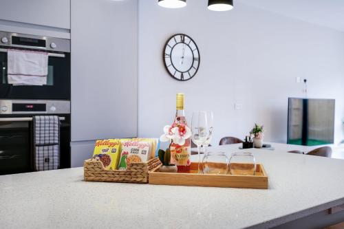 a basket of food and wine on a kitchen counter at Luxury 5 Bedroom, 4 Bathroom Home in Purley in Purley