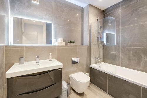 a bathroom with a sink and a toilet and a tub at Luxury 5 Bedroom, 4 Bathroom Home in Purley in Purley