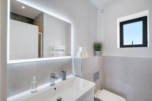 a white bathroom with a sink and a toilet at Luxury 5 Bedroom, 4 Bathroom Home in Purley in Purley
