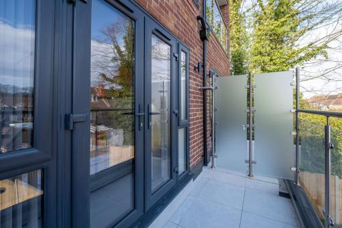 an open glass door on a brick building with a patio at Luxury 5 Bedroom, 4 Bathroom Home in Purley in Purley