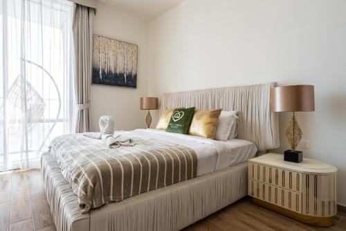 a bedroom with a large bed and a window at Simply Comfort Vacation Homes Rental Luxury 2Br Apt Stunning Views in Amna Tower in Dubai