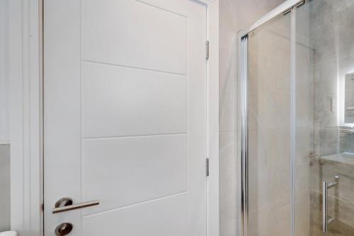 a white shower with a glass door in a bathroom at Luxury 5 Bedroom, 4 Bathroom Home in Purley in Purley