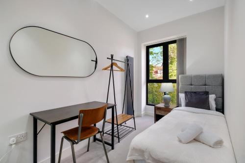 a bedroom with a bed and a desk and a mirror at Luxury 5 Bedroom, 4 Bathroom Home in Purley in Purley