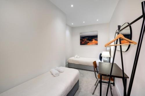 a small room with two beds and a chair at Luxury 5 Bedroom, 4 Bathroom Home in Purley in Purley
