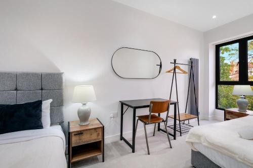 a bedroom with a bed and a desk with a mirror at Luxury 5 Bedroom, 4 Bathroom Home in Purley in Purley