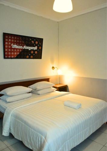 Una cama o camas en una habitación de Wisma Anugerah