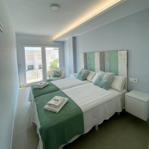 a bedroom with a large bed with a green blanket at MAR y CALMA NG in Benicarló