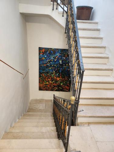 a painting on the wall next to a stairway at La Maison Royale in Toritto