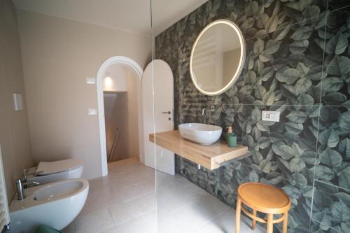 a bathroom with a sink and a mirror at Uniconico Trullo & Rooms in Alberobello