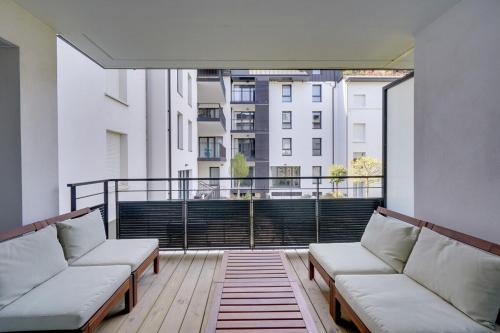 Elle comprend un balcon avec deux canapés blancs et une grande fenêtre. dans l'établissement Appartement Dune-Arcachon centre, à Arcachon