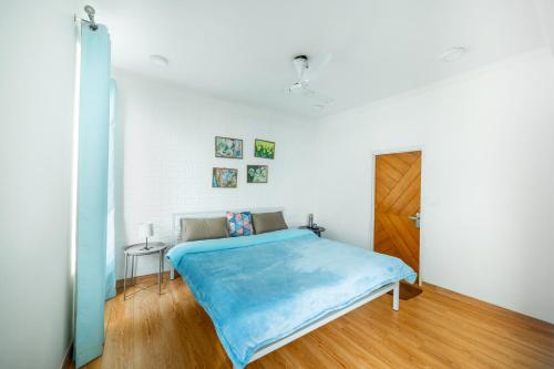 a bedroom with a bed with a blue blanket at Sagittarius by The StayCationer in Mussoorie